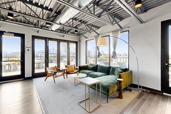 A living room with a couch, chairs, and a table.